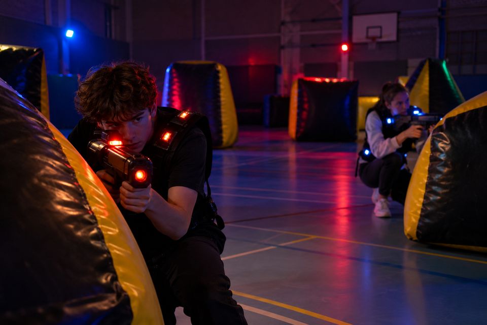 Sporthal met opblaasbare obstakels en gedimd licht voor lasergame Sporthal met opblaasbare obstakels en gedimd licht voor lasergame